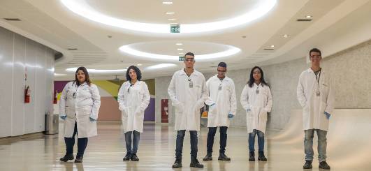 Seis cientistas da Petrobras lado a lado, de jaleco.