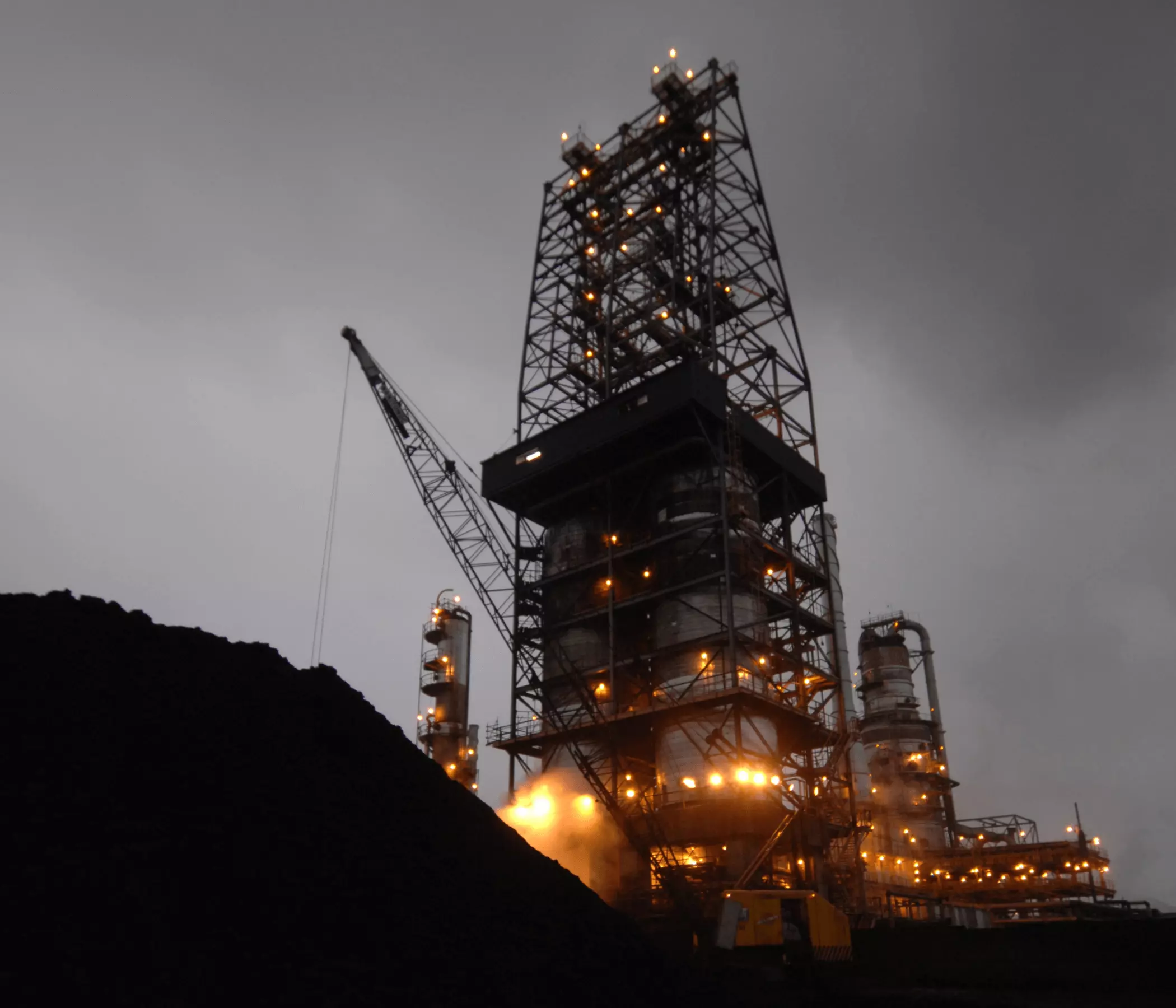 Foto noturna de uma operação da Petrobras, representando a origem do coque verde de petróleo.