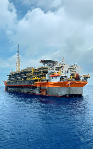 Imagem da plataforma FPSO Almirante Tamandaré, localizada no campo de Búzios, em alto-mar, sob céu parcialmente nublado.