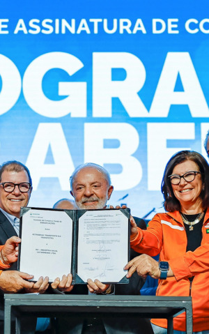 O presidente Lula e executivos da Petrobras e Transpetro seguram um contrato assinado em frente a um painel azul com a inscrição "Programa Mar Aberto".