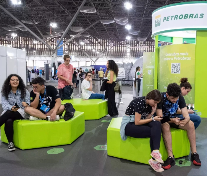 Fotografia de stand da Petrobras em um evento, com diversas pessoas interagindo entre si.