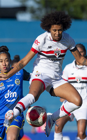 mulher saltando com bola de futebol