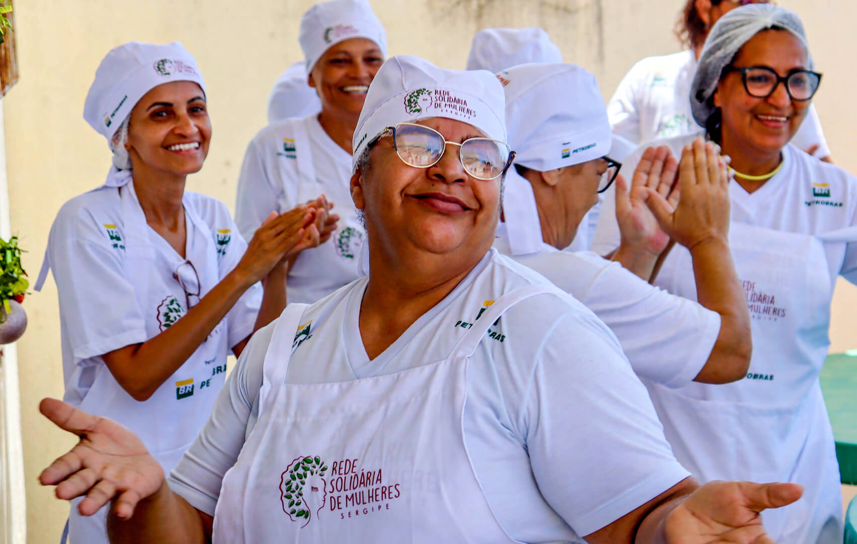 Grupo de mulheres com uniforme branco do projeto Rede Solidária de Mulheres do Sergipe.