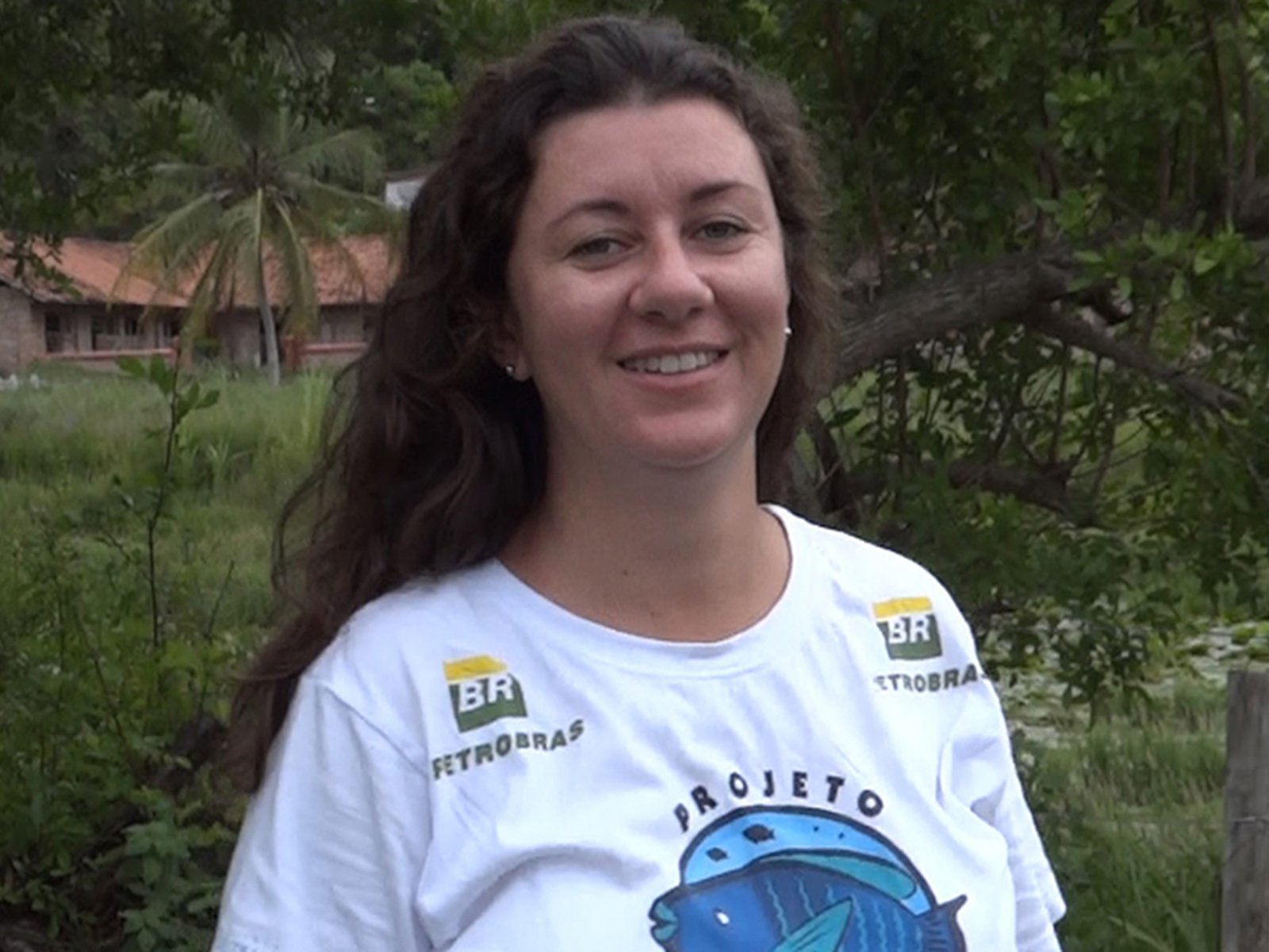 Foto de Marina Tischer. Ela é branca, de cabelos longos, e veste uma camiseta do projeto Budiões.