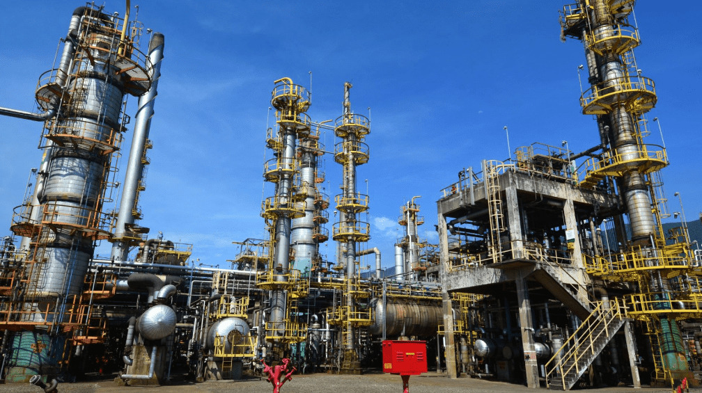 Fotografia diurna da Refinaria Presidente Bernardes em Cubatão, mostrando suas estruturas de metal.