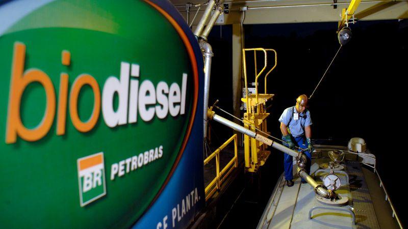 Colaborador em cima de caminhão enchendo o tanque de biodiesel, uma das fontes renováveis usadas na matriz energética brasileira
